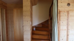 Un interior de madera con una escalera que conduce a una puerta.