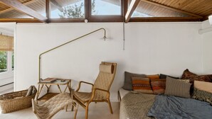 Ein gemütliches Zimmer mit Bett, Stuhl, Tisch und Lampe.