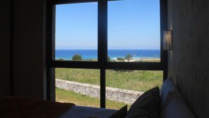 Una habitación con un ventanal grande que ofrece vista al mar y un paisaje con césped.