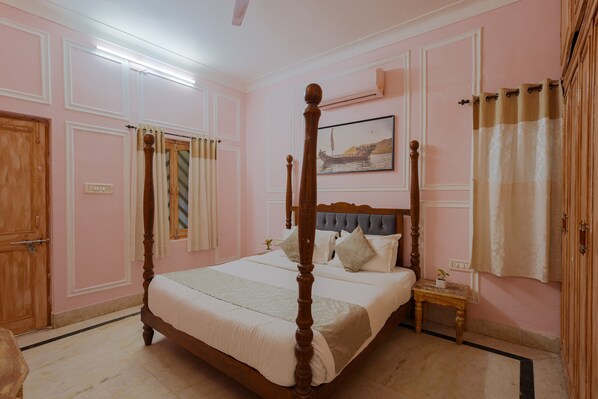 A four-poster bed with a headboard, a bedside table, and a nightstand.