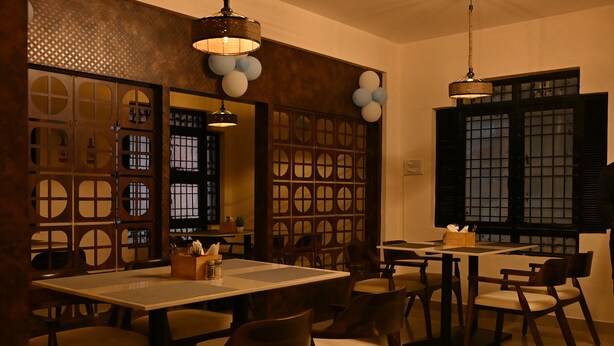Een restaurant met houten meubels, een behang met patroon en een klassiek interieur.