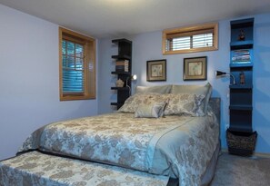 A bedroom with a bed, a window, a bookshelf, and a wall-mounted shelf. - Live like a local in Laurelhurst—family friendly (Portland)