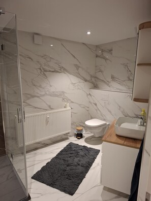 Een douche, handdoeken, toiletpapier