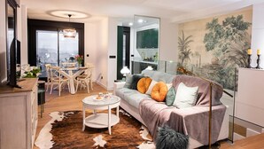 Ein modernes Wohnzimmer mit Sofa, Couchtisch und Essbereich.