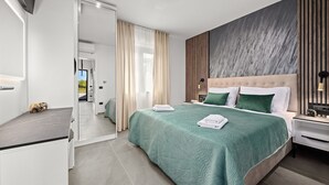 A modern hotel room with a large bed, a flat-screen TV, and a view of the outdoors. - Villa in Štinjan near Hidrobaza Beach (Štinjan)