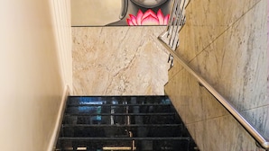 A staircase with a marble wall and a Buddha mural. - Sri Krishna Inn (Devanahalli)
