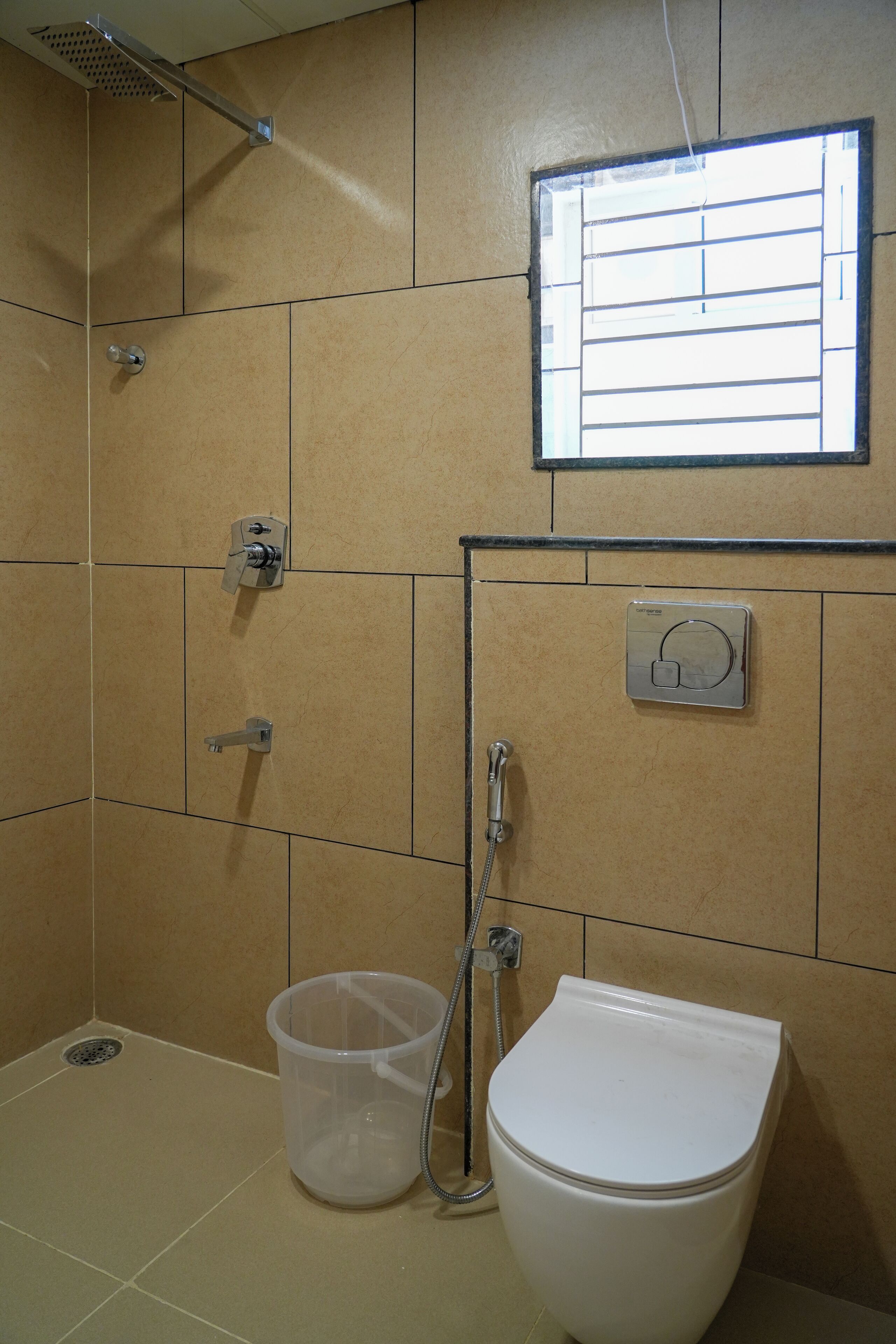 A bathroom with a shower, toilet, and a window.