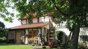 Une maison traditionnelle avec un mur en pierre, une porte en bois et un toit recouvert de tuiles rouges.