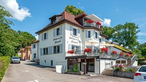 Ein zweistöckiges Gebäude mit Balkon, Treppe und einem Schild, auf dem 'Gästehaus am See' steht.