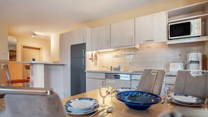Una cucina moderna con zona pranzo, dotata di forno a microonde, tostapane e lavello.