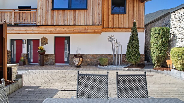 Un bâtiment doté d’une façade en bois, d’une porte rouge et d’un mur en pierre.