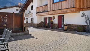 Un bâtiment doté d’une façade en bois, d’un balcon et ayant une chaîne de montagnes en arrière-plan.