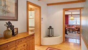 Un intérieur en bois comprenant un coin repas, un vase et un tableau encadré au mur.