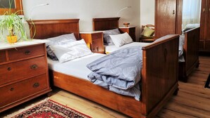 Ein traditionelles hölzernes Bett mit Nachttisch, Kommode und Spiegel.