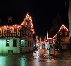 A cobblestone street at night with illuminated buildings.
