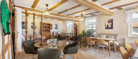 A dining area with wooden beams, a round table, and chairs.