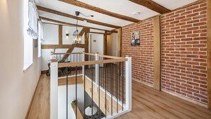 Una escalera con vigas de madera y pared de ladrillo.