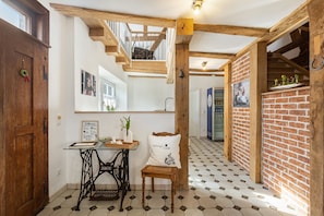 A room with a wooden ceiling, a brick wall, a table with a vase, and a chair with a cushion. - Zeihäänger Stubb Room 'Double Room 3' with Wi-Fi (Schwalmstadt)