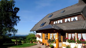 A house with a sloped roof, multiple windows, and a well-maintained garden. - Apartment 'Blumenwiese, 80qm' with Mountain View, Shared Terrace and Wi-Fi (Sankt Peter)