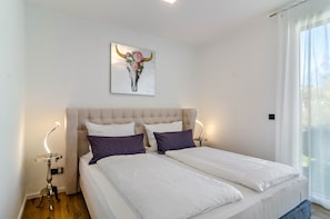 A double bed with white bedding, a tufted headboard, and two bedside tables with lamps. - Apartment 'Purer Genuss - Exklusive' with Mountain View, Wi-Fi and Air Conditioning (Owingen)