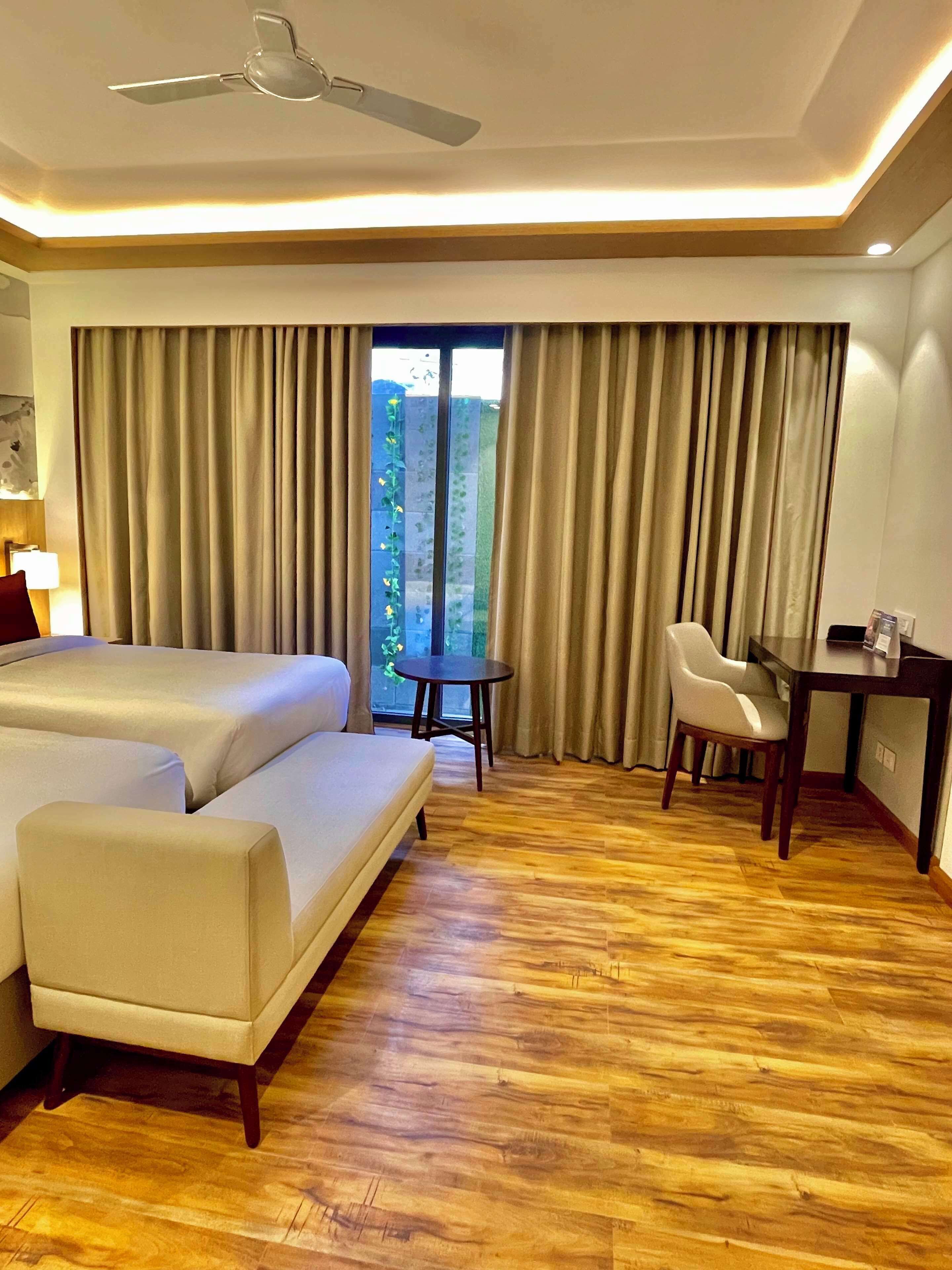 Una habitación de hotel con cama, sofá, escritorio y silla.