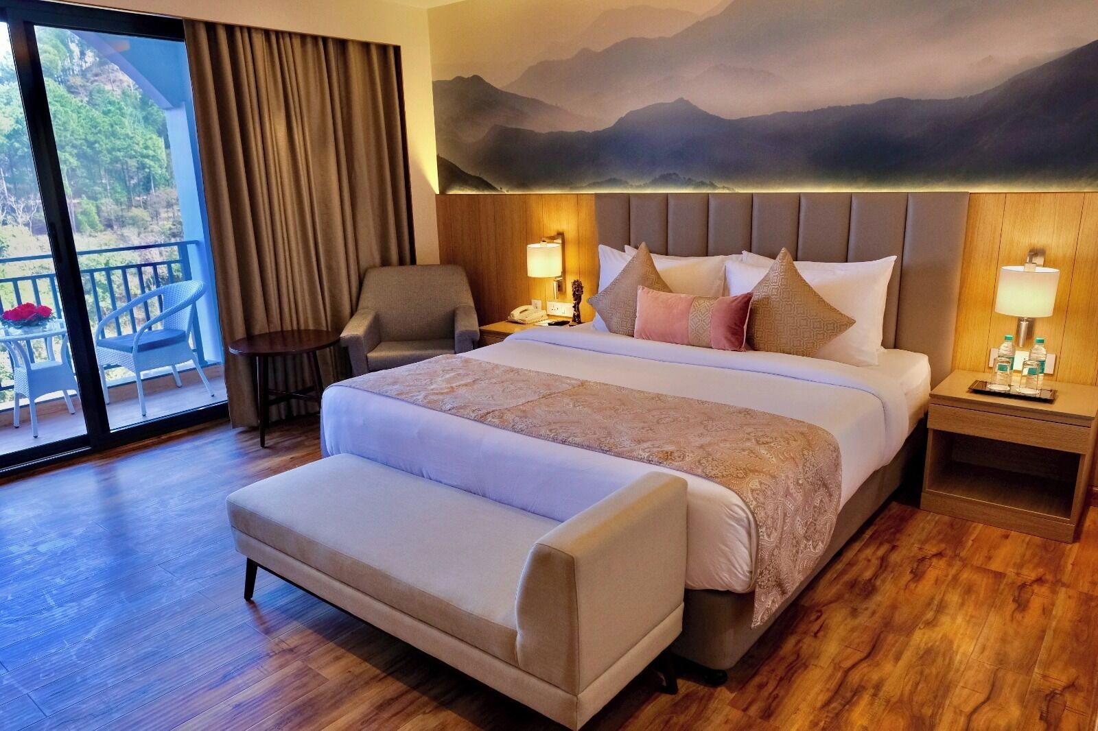 Habitación de hotel con una cama grande, una silla, un escritorio y vistas al exterior.