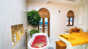 Relax in a serene bathroom with a bathtub, sea views, and a bench for comfort.