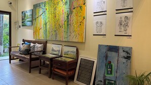 A gallery with various artworks, including paintings and framed sketches, displayed on the wall. - Villa de Mekong (Vientiane)