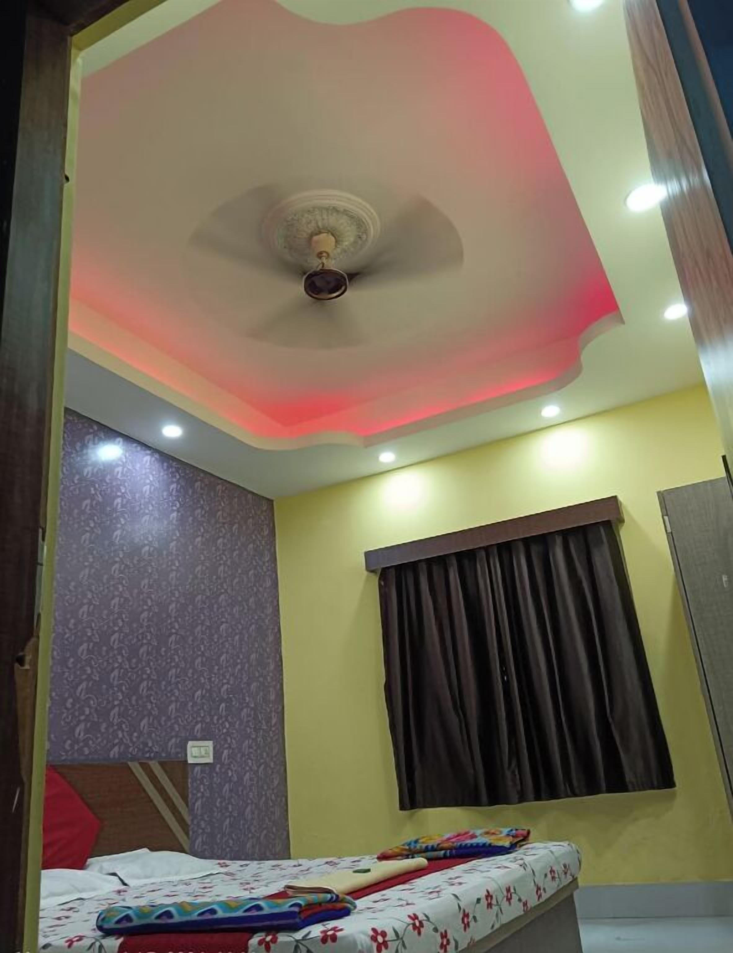 Ein Schlafzimmer mit einem Bett, einem Deckenventilator und einem Fenster mit Vorhängen.