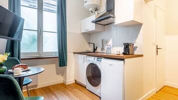 Een koffiezetapparaat/waterkoker, kookgerei, borden en bestek