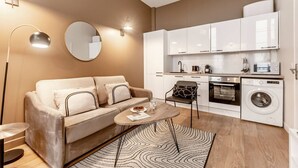 A modern apartment with a sofa, a coffee table, a kitchen with appliances, and a mirror. - A1.RépubliqueMarais1BedRoomParis03AC (Paris)