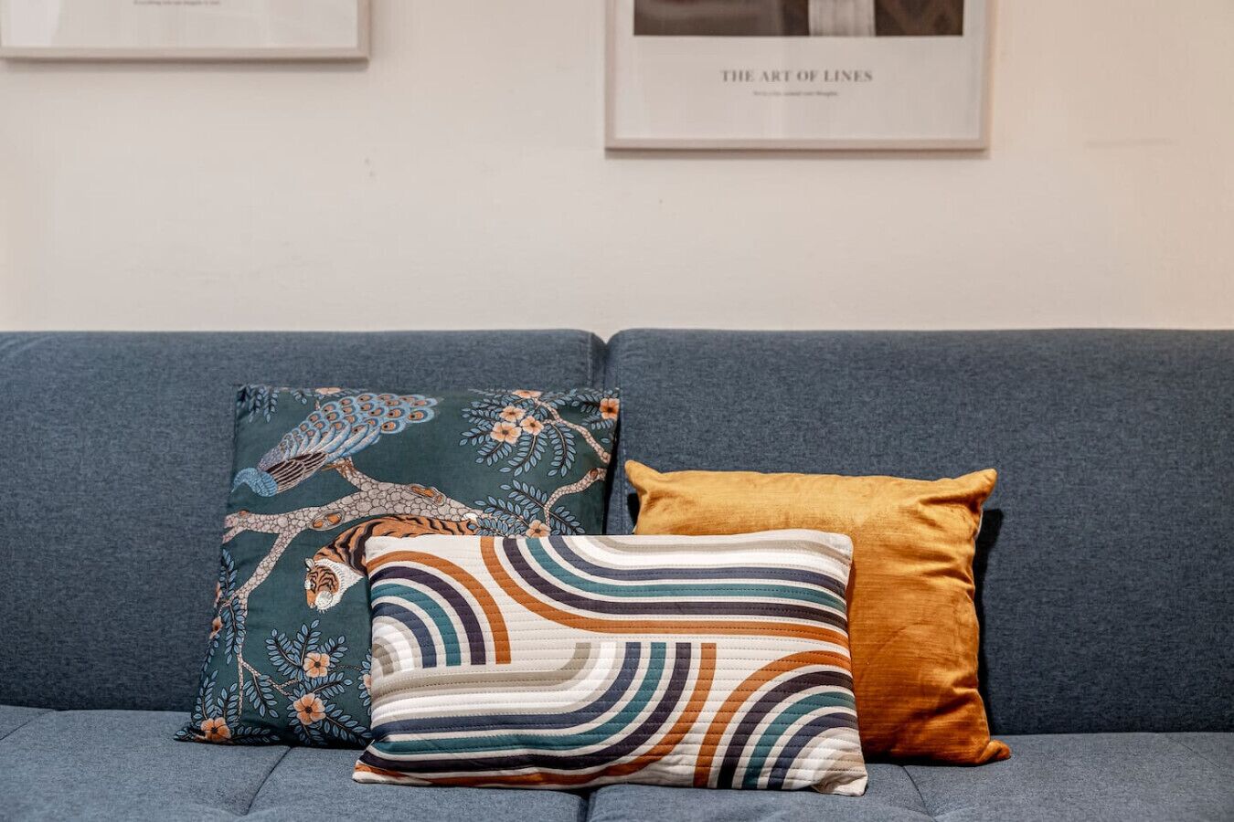 Ein graues Sofa mit drei dekorativen Kissen.