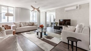 Un salon moderne avec un canapé, une table basse et un téléviseur.