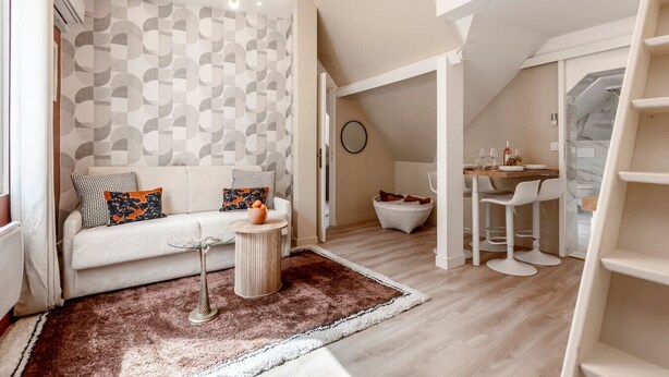 A modern loft apartment with a loft bed, a dining area with white chairs, a round table, and a patterned wall. - A41.République#Marais#1BedRoom#Paris03#AC (Paris)