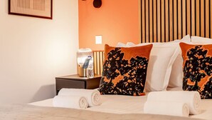 A hotel room with a bed, pillows, a nightstand, a lamp, and a water bottle. - A41.République#Marais#1BedRoom#Paris03#AC (Paris)