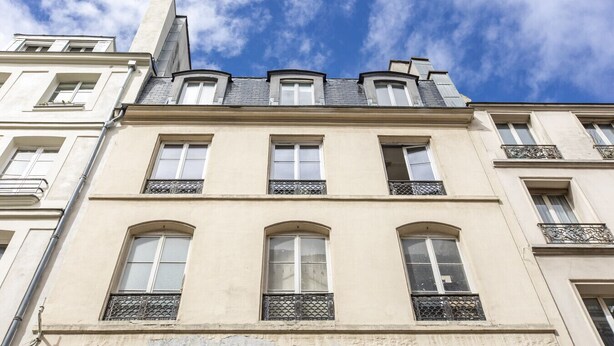 A multi-story building with a classic architectural style, featuring arched windows and decorative balconies.