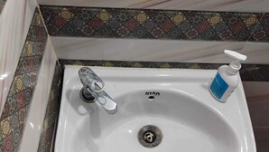 A white sink with a single faucet and a soap dispenser. - Geeta Teerth Guest House (Faizabad)