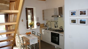 Une cuisine équipée d’une table à manger, de chaises, d’une cuisinière et d’un évier.