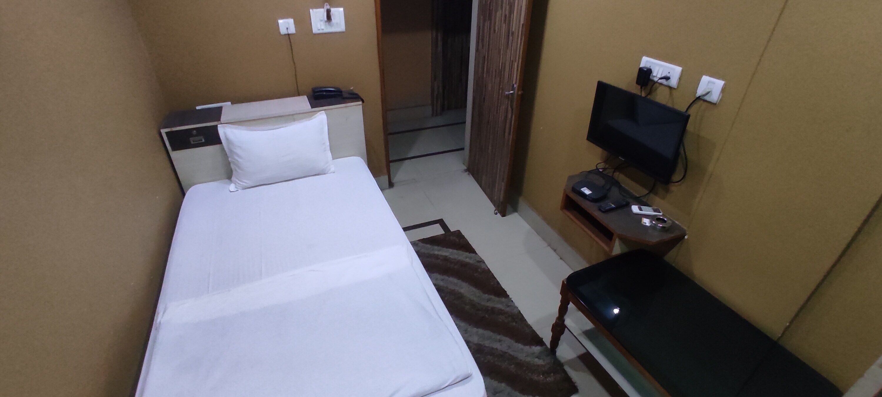 Une chambre d’hôtel avec un lit, une télévision, un bureau et une chaise.