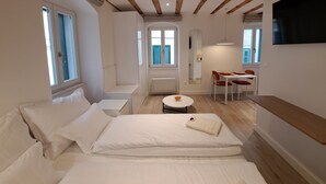 Una camera da letto moderna con un letto, un tavolino rotondo e una TV a muro.