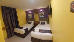 A hotel room with two beds, a large window with curtains, and a wall-mounted TV. - Enrich Hotel Puncak Alam by uBook (Ijok)