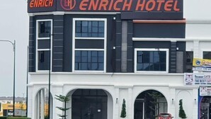 A modern hotel building with a prominent ENRICH HOTEL sign. - Enrich Hotel Puncak Alam by uBook (Ijok)