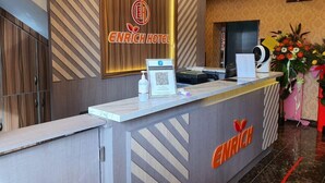 A hotel reception desk with a modern design, a logo, and a QR code. - Enrich Hotel Puncak Alam by uBook (Ijok)