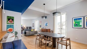 A modern apartment with a dining area, kitchen, and living space.