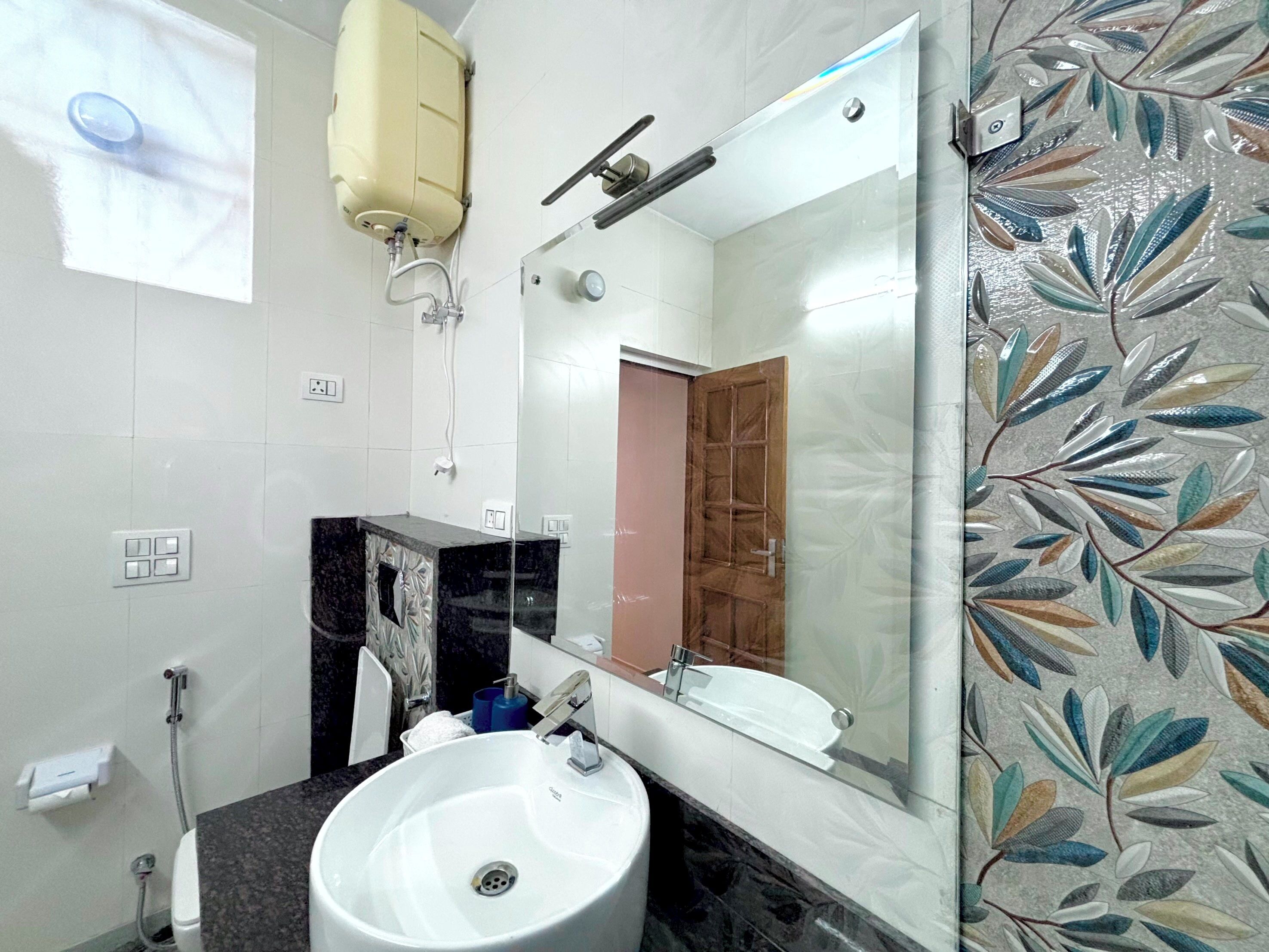 A bathroom with a white sink, a mirror, a shower, and a toilet.