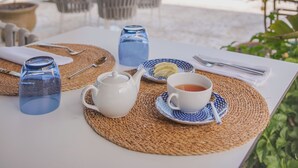 A table set for tea with a view of a pool and palm trees. - VILLA SALISA' (Menfi)