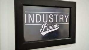 Un cartel enmarco con el texto 'INDUSTRY Room'.