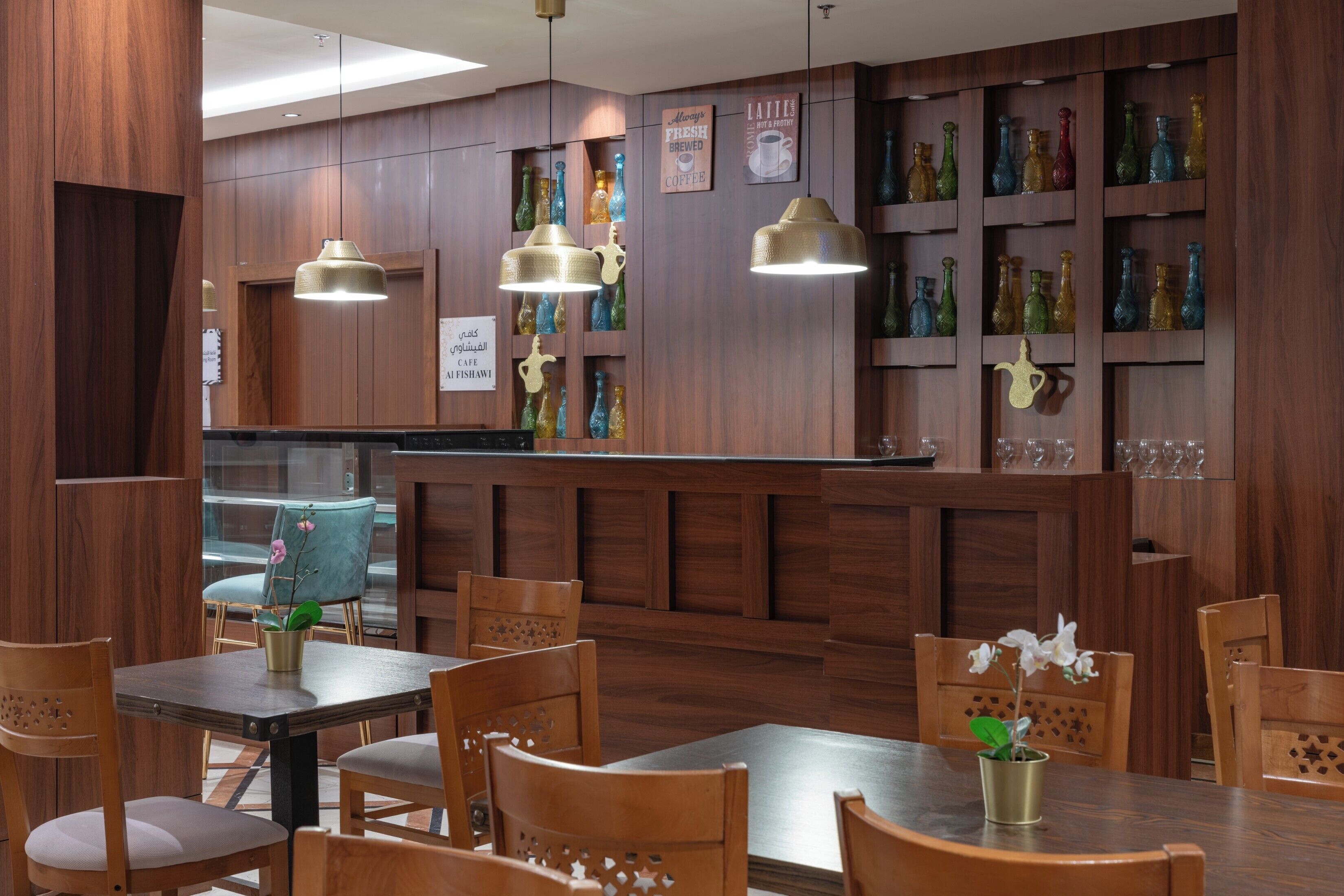 L’intérieur d’un restaurant est agrémenté de lambris en bois, de luminaires suspendus, d’un bar et d’un espace aménagé avec des sièges.