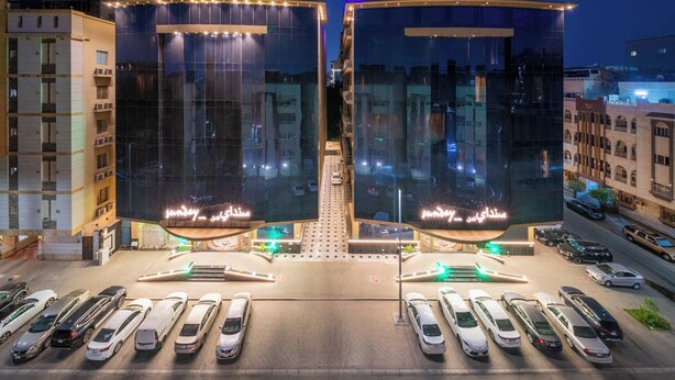 A modern building with a glass facade and illuminated signage. - Sunday Harbour Gateway Jeddah Beach Formerly Vivid Plaza Hotel (Jeddah)