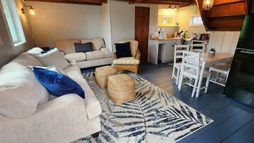 A cozy living room with a sofa, two armchairs, a coffee table, and a patterned rug.